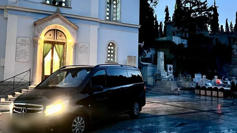 Bestattungswagen an einer Kirche am Abend