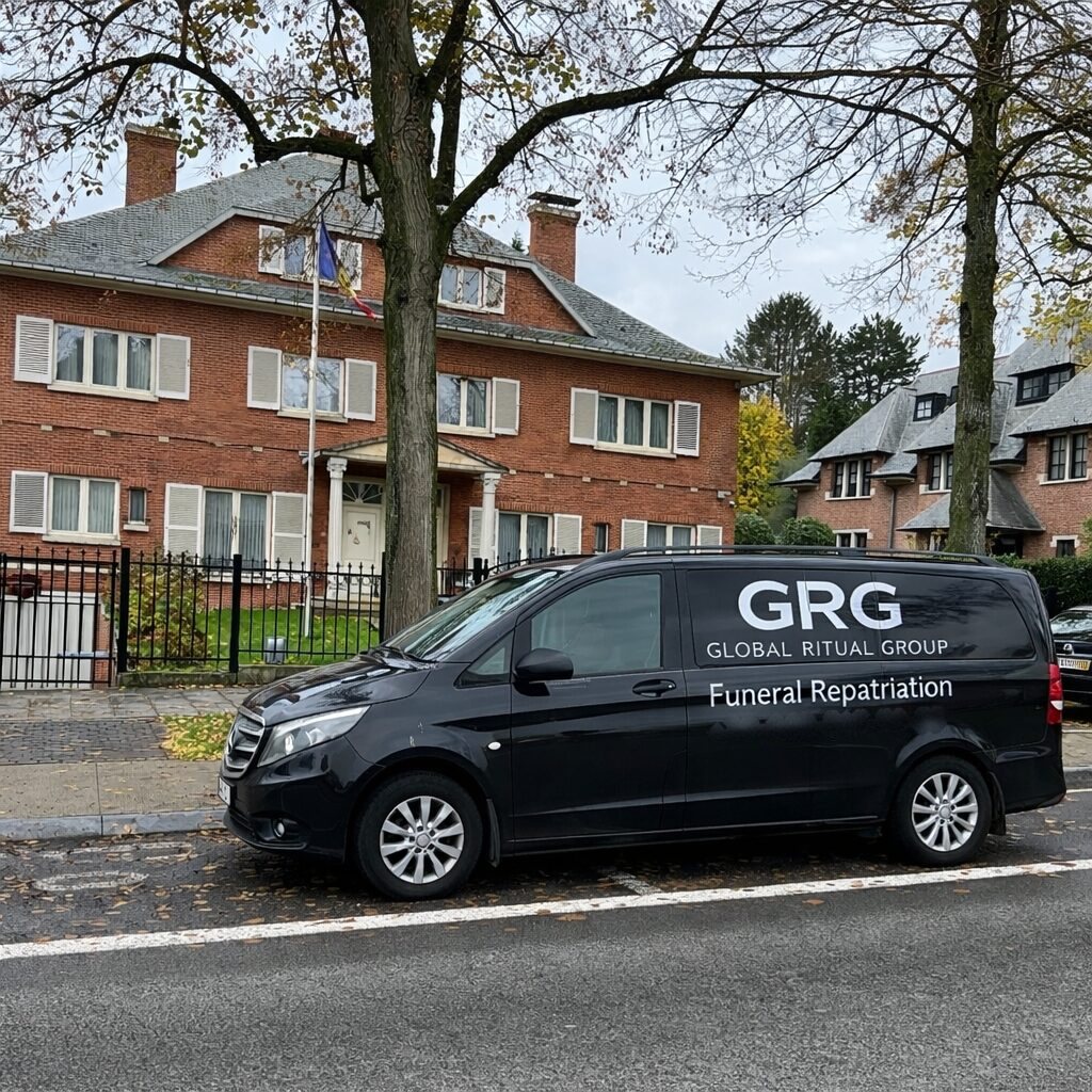 Van in front of a brick building with a flag